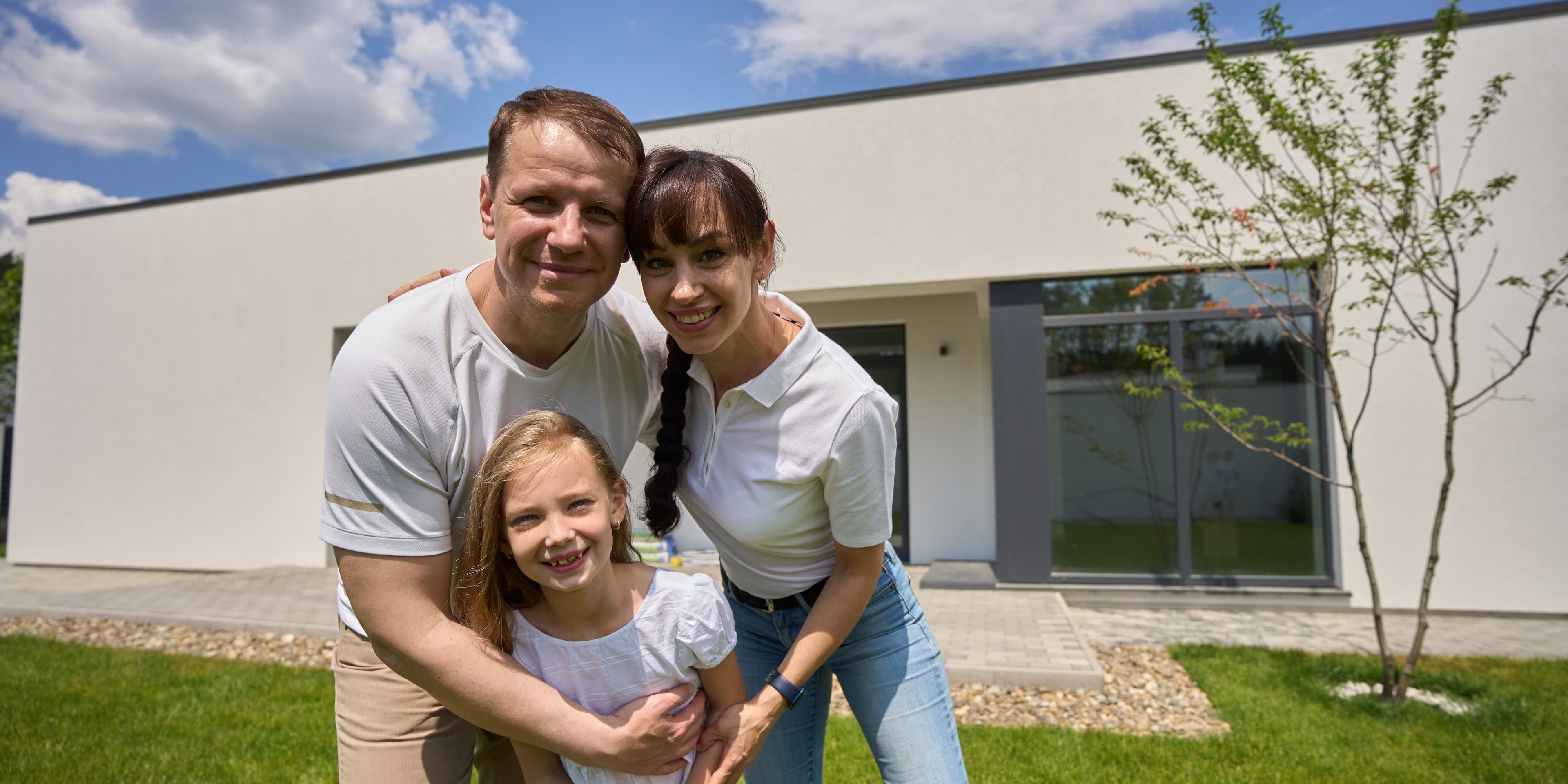 Happy family standing in front of their new home in Dubai after property purchase